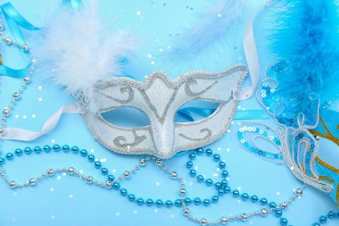 Carnival mask with beads and confetti on blue background