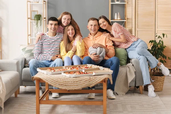 Group of friends sitting on sofa in living room