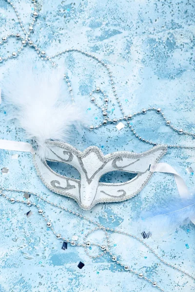 Carnival mask with beads and confetti on grunge background