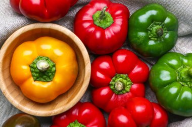 Fresh bell peppers on fabric background, closeup