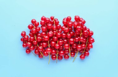 Heap of ripe red currant on color background