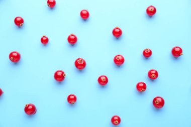 Ripe red currant scattered on color background