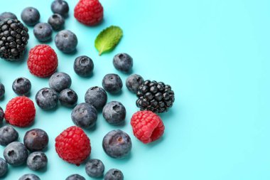 Different fresh ripe berries on color background, closeup