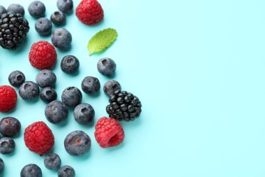 Different fresh ripe berries on color background