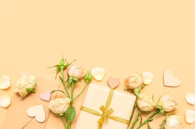 Composition with gift box, envelope, rose flowers and decor on color background