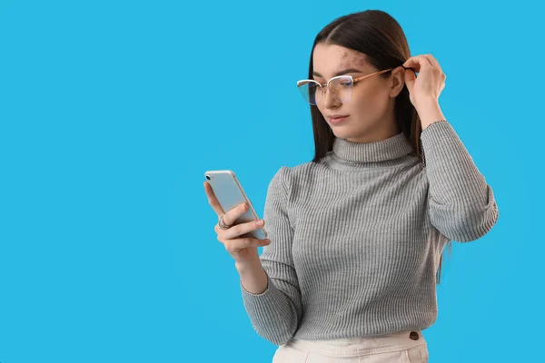 Young Woman Eyeglasses Using Mobile Phone Blue Background — Foto Stock