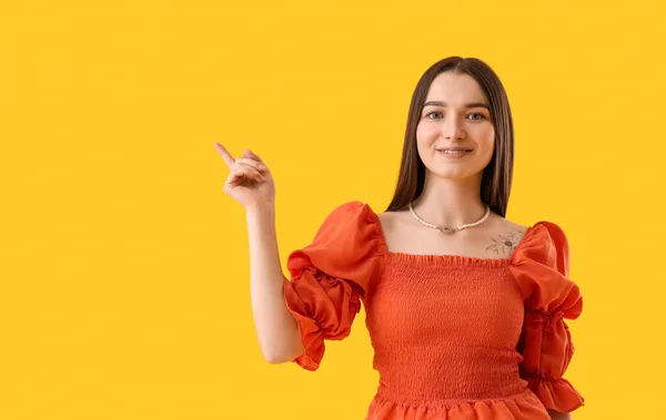 Young Woman Stylish Blouse Pointing Something Yellow Background — Foto Stock