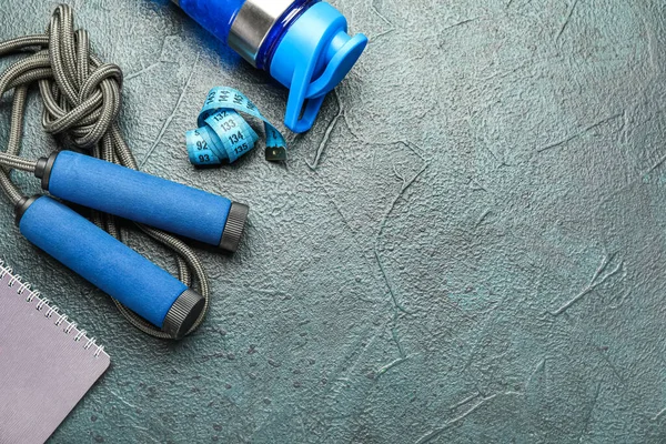 Skipping rope with bottle on grunge background, closeup