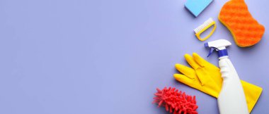 Flat lay composition with cleaning supplies on lilac background with space for text