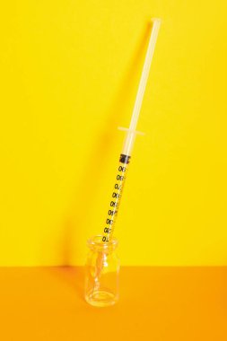 Medical syringe with ampule on color background