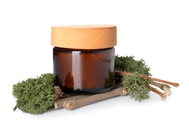 Jar of cream with green moss and tree branches on white background