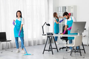 Young janitors cleaning in modern office