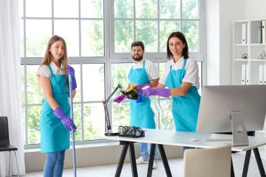 Young janitors cleaning in modern office