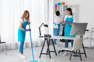 Young janitors cleaning in modern office