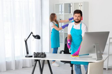 Young janitors cleaning in modern office