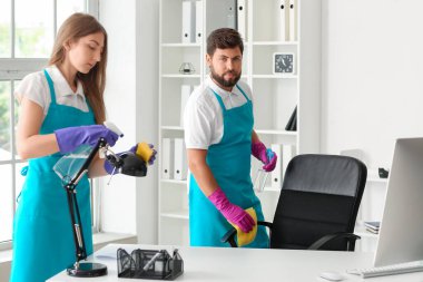 Young janitors cleaning in modern office