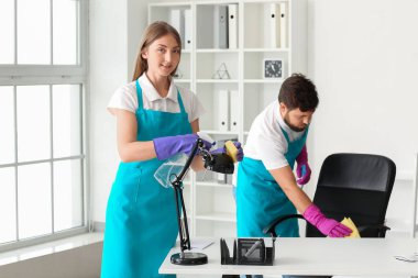 Young janitors cleaning in modern office