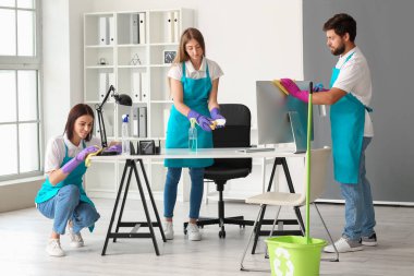 Young janitors cleaning in modern office