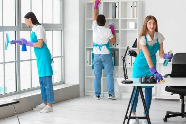 Young janitors cleaning in modern office