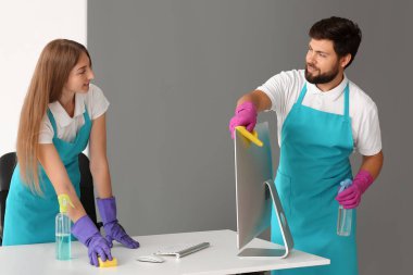 Young janitors cleaning in modern office