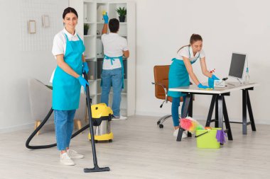 Young janitors cleaning in modern office