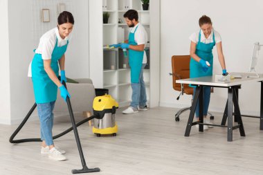 Young janitors cleaning in modern office