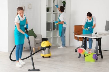 Young janitors cleaning in modern office