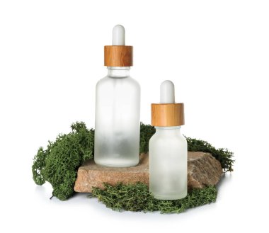 Cosmetic dropper bottles with green moss and rock on white background