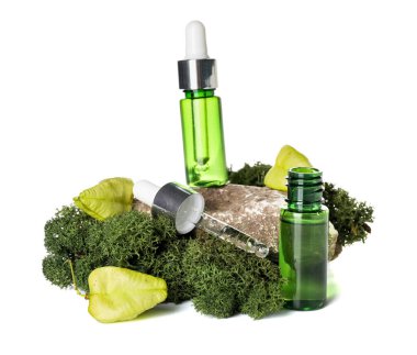 Cosmetic dropper bottles with green moss and rock on white background