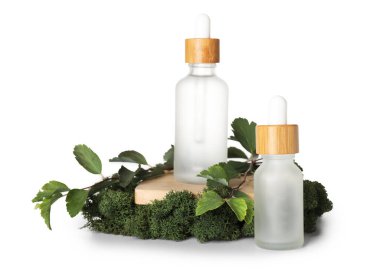 Cosmetic dropper bottles with green moss, plant branches and stand on white background