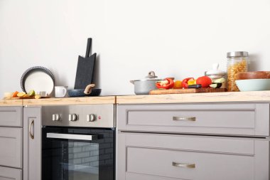 Interior of modern kitchen with grey counter, oven and food