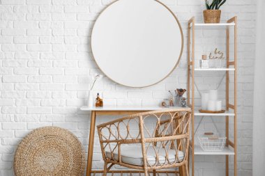 Interior of stylish makeup room with table, mirror and shelving unit