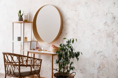 Interior of stylish makeup room with table, mirror and shelving unit