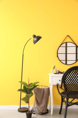 Interior of stylish makeup room with table, mirror and lamp