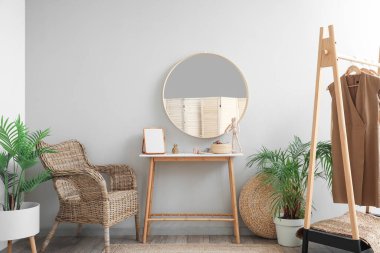 Interior of stylish makeup room with table, mirror and armchair