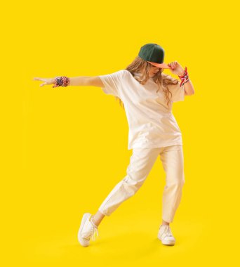 Female hip-hop dancer on yellow background
