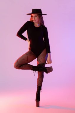 Attractive female dancer in high heels on color background