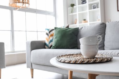 Cups on table in modern living room, closeup