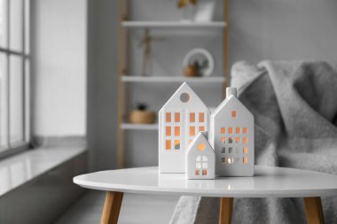 House candle holders on table in light living room, closeup