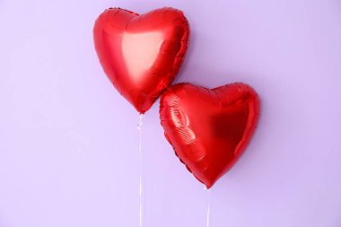 Heart shaped balloons for Valentine's Day on lilac background