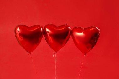 Heart shaped balloons for Valentine's Day on red background