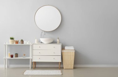 Interior of bathroom with ceramic sink, drawers and mirror