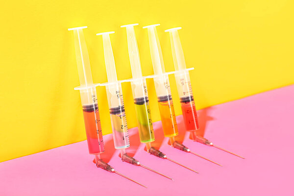 Medical syringes with remedy on color background