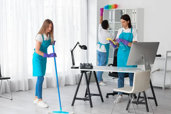 Young janitors cleaning in modern office