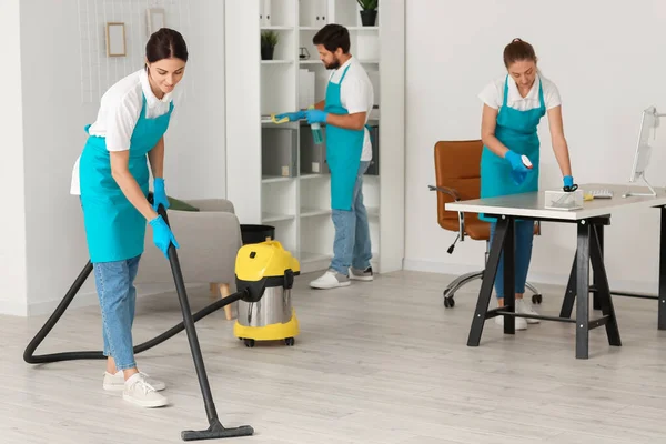 Young janitors cleaning in modern office