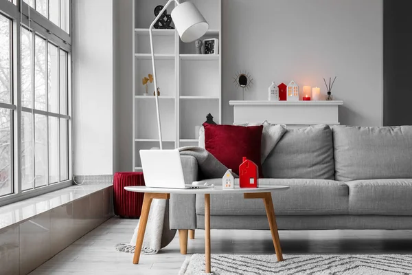 Interior of living room with house candle holders and laptop on table
