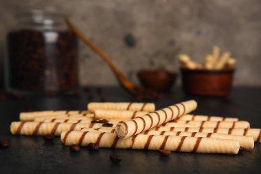 Heap of tasty wafer rolls on dark grunge table