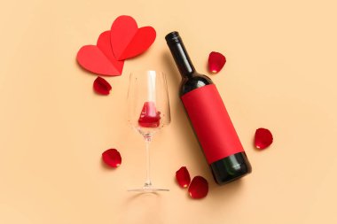 Composition with bottle of wine, glass and rose petals on color background. Valentines Day celebration
