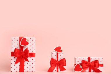 Gift boxes with beautiful bows on pink background. Valentine's Day celebration