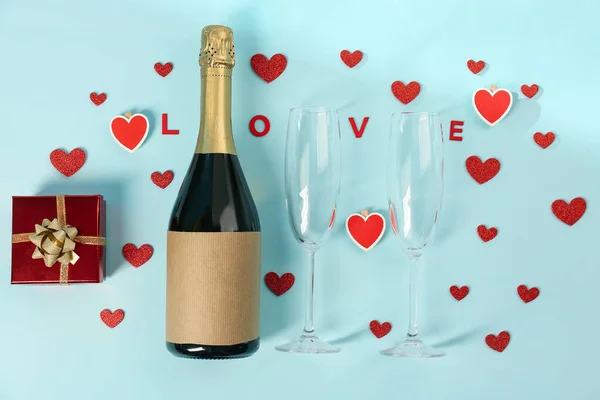 Bottle of wine, hearts, gift and word LOVE on blue background. Valentine\'s Day Celebration